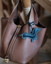 Bijou en cuir teckel, sac à main présenté à plat, soulignant son design.