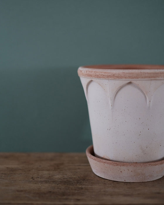 Pot de rangement en céramique avec des motifs stylisés, offrant une solution pratique et esthétique.