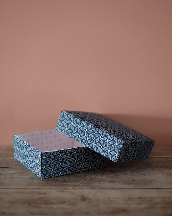 Boîte de stockage en carton avec un design élégant, adaptée pour une utilisation bureau ou domestique.